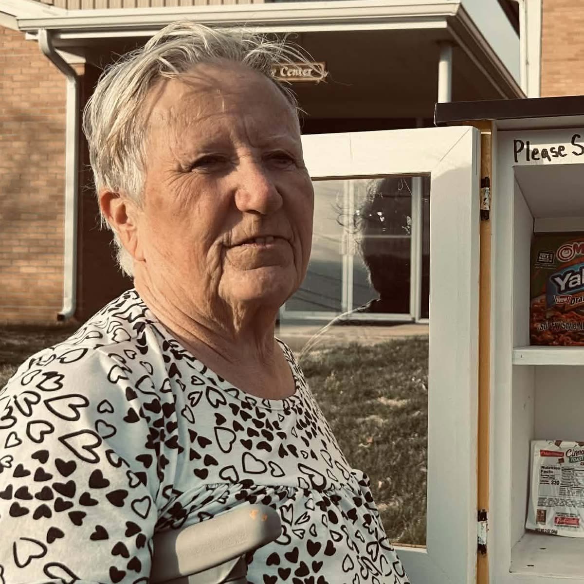 Roxana Boroujerdi, founder and director of Faith Mobile Food Bank, beside an open Blessing Box stocked with food