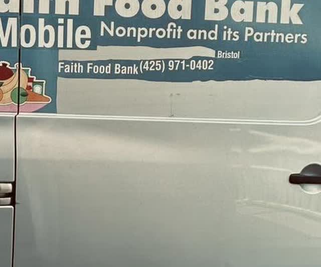 The side of the Faith Mobile Food Bank van with the food bank's name and phone number painted on it